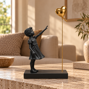 A Little Hope sculpture in black & gold, displayed in a styled interior