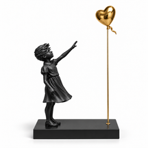 A Little Hope sculpture in black & gold, on a white studio background