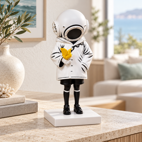Deep Sea Dreamer sculpture in white & black with yellow bird, displayed in a styled interior