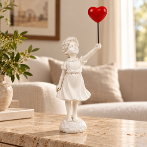 Held in Hope girl with heart balloon sculpture in white & red, displayed in a styled interior
