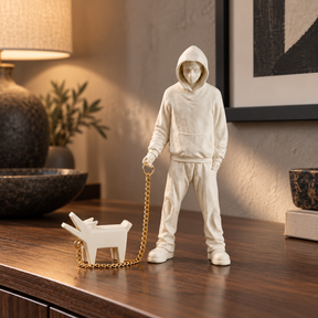 Urban Companion hooded figure and dog sculpture in white & gold, displayed in a styled interior