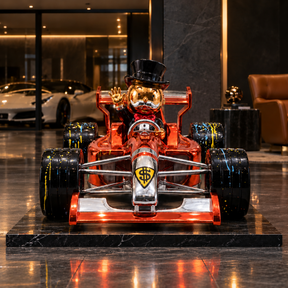 Grand Prix Royale Lifesize™ copper-orange racing car sculpture, direct front view with gold-toned driver and black splatter-detail wheels